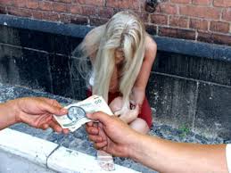 siedząca kobieta, przed nią dłonie trzymające banknot