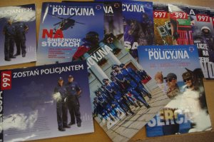 gazety, broszury o zawodzie policjanta w tle blat stołu