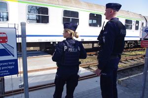 policjanci na dworcu kolejowym w tle stacja i pociąg