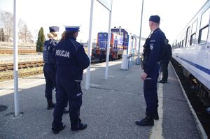 policjanci na dworcu kolejowym w tle stacja i pociąg
