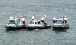 trzy policyjne łodzie motorowe na wodzie