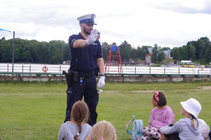 policjanci rozmawiają z uczestnikami w tle jezioro i zieleń