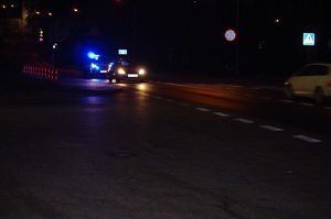 policja zatrzymuje pojazd do kontroli nocą, w tle ulica