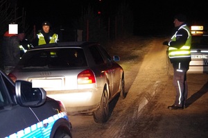 policyjny patrol wieczorową porą kontroluje pojazd w tle droga