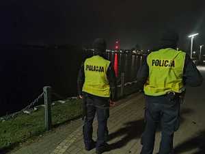 policjanci kontrolują promenadę jeziora Raduń w tle zabudowania