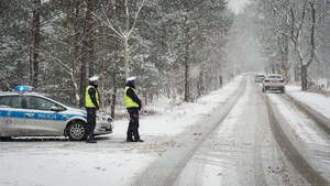policjanci kontrolują samochody w tle zaśnieżone drogi