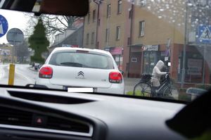 policjant kontroluje pojazd w tle ruch uliczny