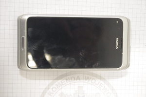 telefon komórkowy na tle kartki z logo policji Wałcz