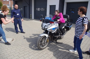 dziewczyna na policyjnym motocyklu w tle garaże