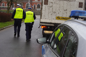 policjanci kontrolują ciężarówkę w tle zabudowania