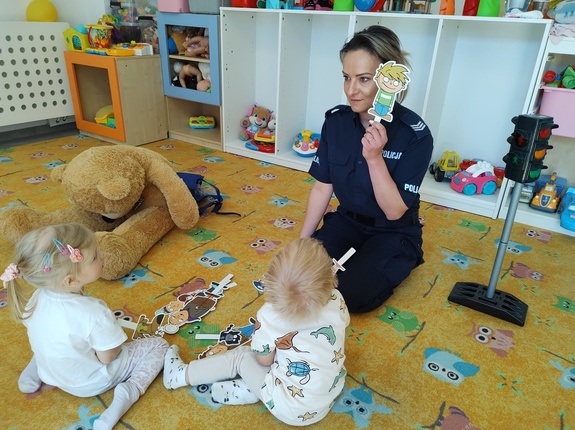 policjantka pokazuje dzieciom kukiełkę w tle sala