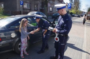 policjantka pochyla się witając z dziećmi