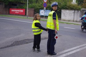 policjantka trzyma dziecko za rękę, stoją na ulicy