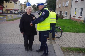 policjant rozmawia z kobietą, w tle ulica