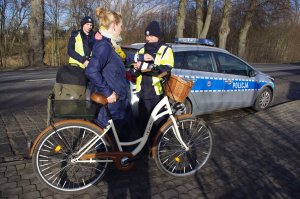 policjantka rozmawia z rowerzystką, w tle radiowóz