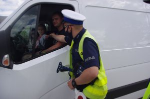 policjant rozmawia z kierowcą busa, w środku dziecko