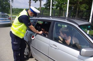 kontrola kierującego, policjant wręcza magnes dziecku
