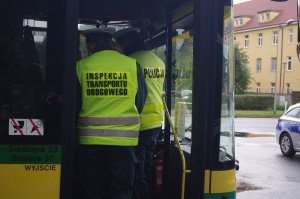 drogówka i ITD sprawdzają autobus w tle ulica