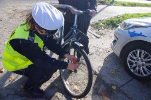 policjantka zakłada odblaski na koła rowerowe