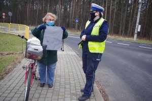 rowerzystka prezentuje otrzymany workoplecak, w tle ulica