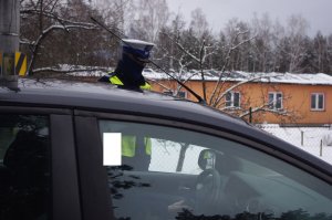 policjant drogówki bada stan trzeźwości kierowcy, w tle ulica