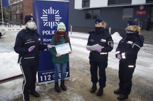 policjantki i uczestniczka konkursu przy banerze komendy
