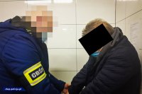 policjant nieumundurowany z zakrytą twarzą zakłada kajdanki na ręce mężczyźnie z zakrytą twarzą
