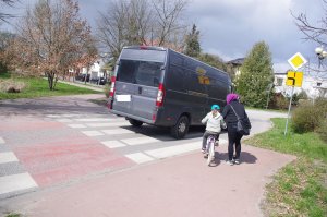 BUS na drodze, przy przejściu dla pieszych kobieta i dziecko na rowerze