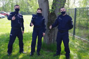 wpólne zdjęcie młodych policjantów na tle zieleni teren komendy