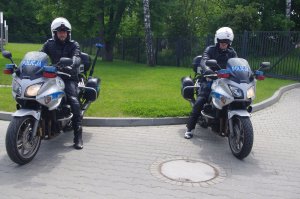 policjanci na motocyklach pozują do zdjęcia w tle