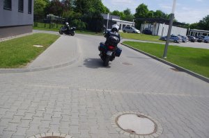 policjanci oddalający się na motocyklach, w tle teren jednostki