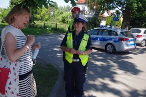 policjantka rozmawia z kobietą, w tle zabudowania