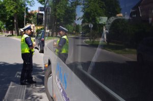 policjantka sprawdza autobus, w tle ulica