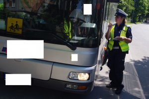 policjantka sprawdza autobus, w tle ulica