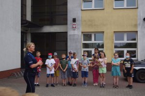 policjantka rozmawia z uczniami w tle szkoła