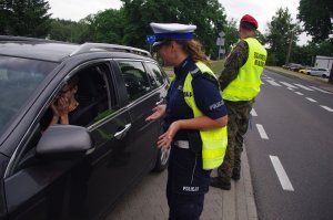 policjantka rozmawia z kierowcą w tle auto