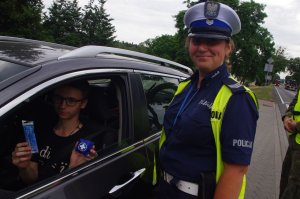 policjantka rozmawia z kierowcą  w tle auto