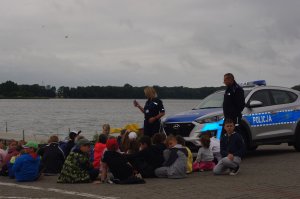 dzieci i policjanci w tle jezioro