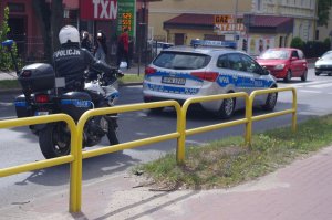 radiowóz i motocykl policyjny, w tle ulica
