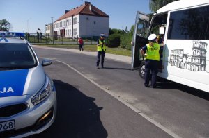 policjantki kontrolują autobus   w tle zabudowania