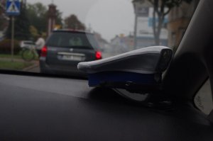 czapka policyjna w radiowozie w tle ulica i pojazd