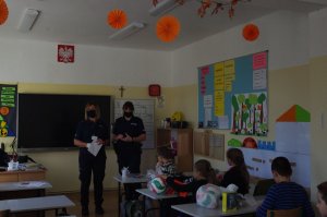 policjantki wręczają nagrody uczniom w tle sala lekcyjna