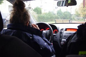 policjantka w radiowozie w tle droga i drzewa