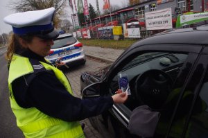 policjantka kontroluje pojazd w tle ulica