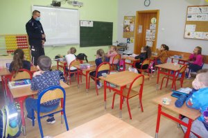 policjant rozmawia z dziećmi w tle klasa