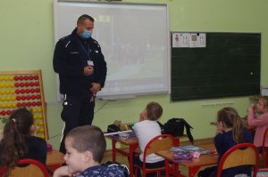 policjant rozmawia z dziećmi w tle klasa