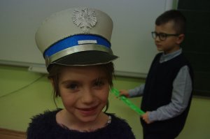 dziewczynka w czapce policyjnej w tle sala