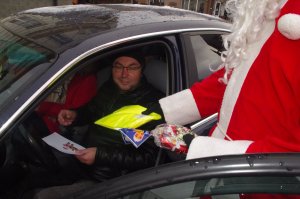 Mikołaj rozmawia z kierowcą  w tle miasto