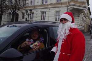 Mikołaj rozmawia z kierowcą  w tle miasto