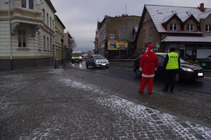 Mikołaj i policjantka zatrzymują pojazdy  w tle miasto